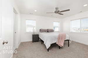 Bedroom with multiple windows, visible vents, and carpet
