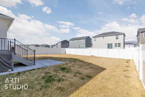 View of yard with a fenced backyard, a residential view, and a patio