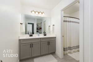 Bathroom with wood finished floors, a sink, a shower with shower curtain, and double vanity