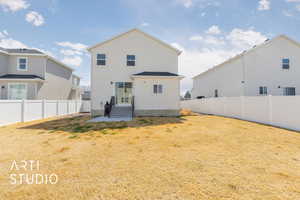 Rear view of property featuring a lawn and a fenced backyard