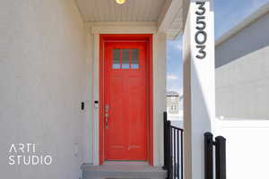 Doorway to property featuring stucco siding