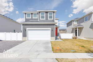 View of front of house featuring a gate, fence, board and batten siding, and a front yard