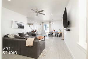 Living room with ceiling fan, baseboards, light wood finished floors, and recessed lighting