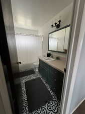 Bathroom with vanity, curtained shower, and toilet