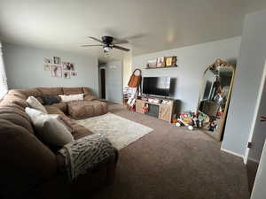 Living area featuring carpet and a ceiling fan