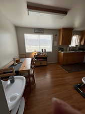 Dining space with plenty of natural light, beam ceiling, and dark wood finished floors