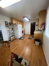 Kitchen with light countertops, light wood-style floors, and white appliances