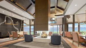 Lobby with a towering ceiling, a mountain view, recessed lighting, beam ceiling, and a wall of windows