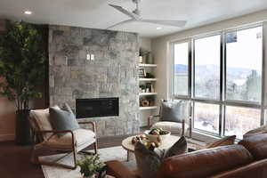 Living room featuring a fireplace, a ceiling fan, wood finished floors, and recessed lighting
