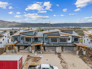 Unfinished property with a mountain view, an attached garage, and dirt driveway