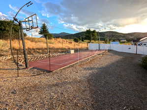 A rock retaining wall gracefully elevates you to the upper backyard, where you’ll discover two mature peach trees, a fun zipline, and a cleverly designed, slim lighted court ready for a game of pickleball or basketball.