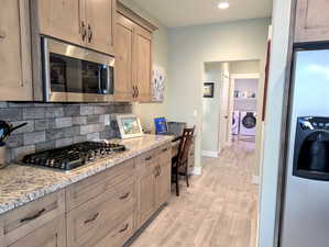 The matching GE appliance suite includes a five-burner gas cooktop for precision cooking, and an over-the-counter microwave with a convection cooking option for added versatility. A built-in computer desk adds a touch of practicality.