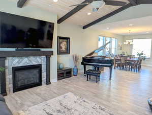 The great room centers around a cozy gas fireplace, flanked by custom cabinets, while large windows invite natural light and views of the front yard.