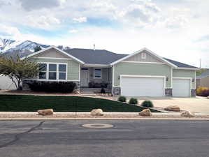 The front yard presents a charming welcome with established bushes and perennials adding natural beauty. Enjoy a low-maintenance landscape with a small, water-wise grass area, while the park strip features attractive landscape rocks.