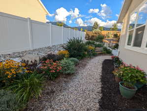 The east side yard offers convenient access from the front through a gate, leading you along a landscape rock pathway bordered by inviting planting areas.