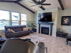 Step into a welcoming expanse where the great room, kitchen, and dining area flow effortlessly together, creating the perfect hub for connection. Above, a custom vaulted wood plank ceiling with striking beams adds architectural interest.