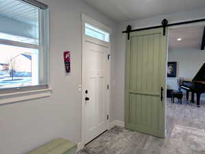 The entry serves as a central connection point, linking the main floor, basement, and garage with ease. A custom-made sliding barn door offers a stylish way to create separation from the great room when desired.