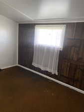 Empty room with baseboards and carpet
