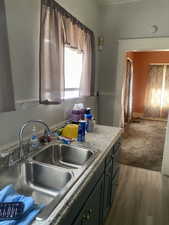 Kitchen with light countertops, wood finished floors, and a sink