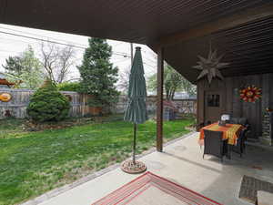 View of patio with outdoor dining space and a fenced backyard