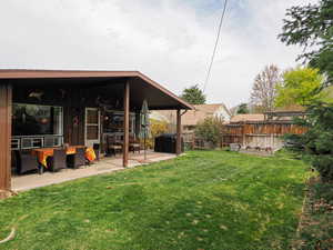 View of yard featuring fence and a patio