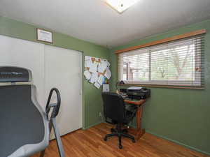 Office space with baseboards and wood finished floors