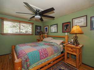 Bedroom featuring ceiling fan, baseboards, and wood finished floors