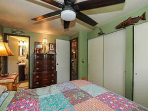 Bedroom featuring connected bathroom, ceiling fan, a sink, and a closet