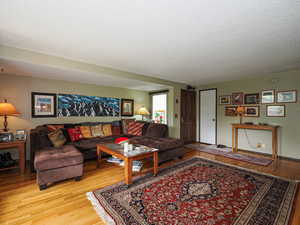 Living area with light wood-style flooring and a textured ceiling