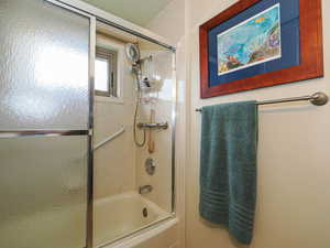 Full bath with combined bath / shower with glass door