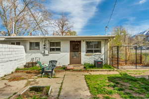 View of front of house featuring fence, concrete block siding, and central air condition unit