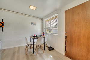 Dining room with wood finished floors and concrete block wall