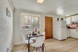 Dining room with light wood-style floors and concrete block wall