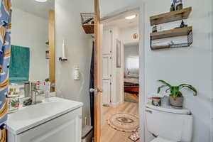 Ensuite bathroom featuring ensuite bathroom, wood finished floors, vanity, and toilet