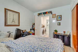 Bedroom with concrete block wall and independent washer and dryer