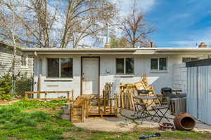 Rear view of house with concrete block siding and fence