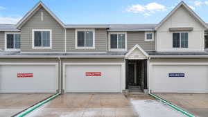 Multi unit property featuring a garage and a shingled roof