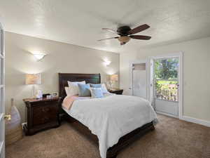 Bedroom featuring light colored carpet, ceiling fan, access to outside, and a textured ceiling