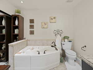 Bathroom with tile patterned flooring, a bath, toilet, and vanity