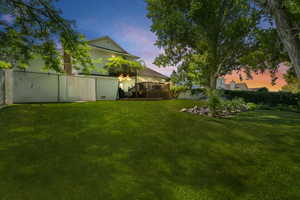 Yard at dusk with a wooden deck and fence