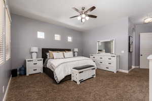 Bedroom featuring dark carpet, a ceiling fan, and baseboards