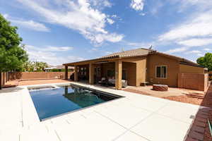 View of pool with a fenced in pool, a fenced backyard, ceiling fan, a patio, and an outdoor fire pit