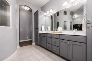 Bathroom with a sink, a spacious closet, double vanity, tile patterned flooring, and visible vents
