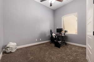 Home office with carpet floors, a ceiling fan, and baseboards