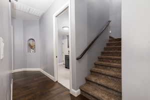 Staircase with baseboards, visible vents, and wood-type flooring