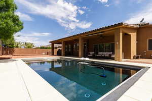 View of swimming pool featuring an outdoor living space, ceiling fan, a fenced backyard, and a patio