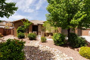 View of front of house featuring a gate, a tile roof, fence private yard, and stucco siding