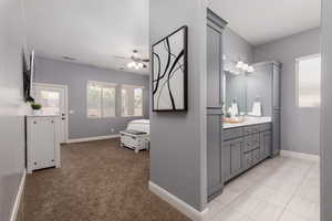 Bathroom featuring visible vents, baseboards, vanity, and ceiling fan