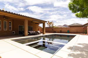 View of swimming pool with a patio area, a fenced backyard, a fenced in pool, an in ground hot tub, and ceiling fan