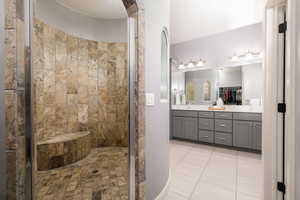 Bathroom featuring double vanity, a shower stall, and tile patterned floors